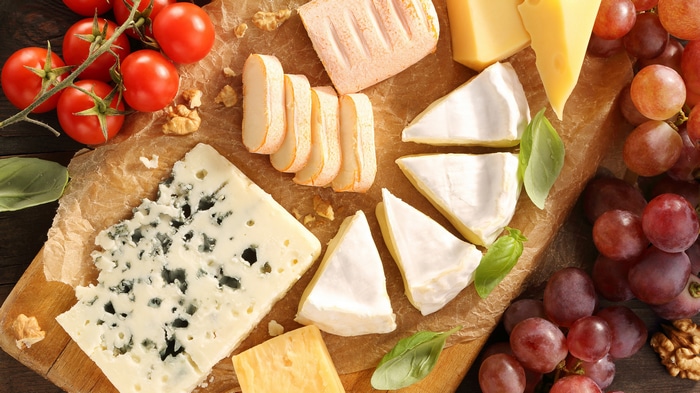 Cheese platter with tomatoes, grapes, and nuts