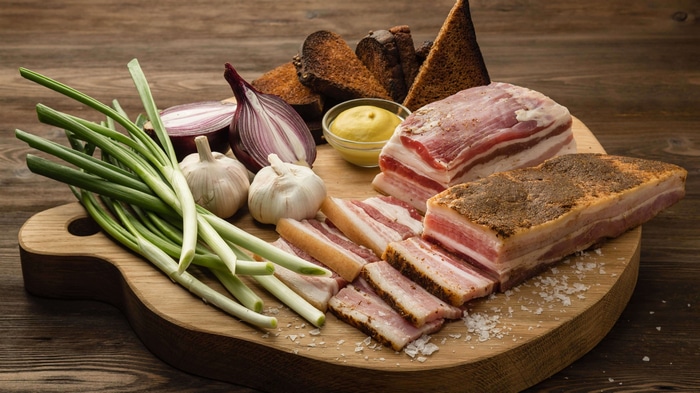 Still life of cured pork belly with onions and garlic