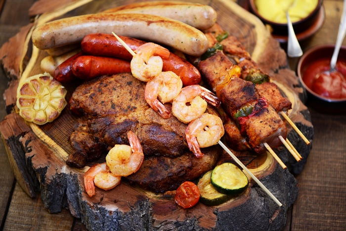 4K close-up of a rustic platter with grilled meats and seafood