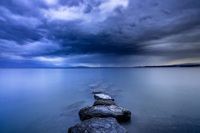 Stormy lake with lightning over mountains and clouds