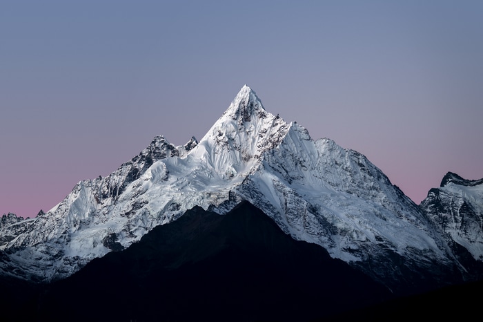 Snow-covered mountains under a twilight sky