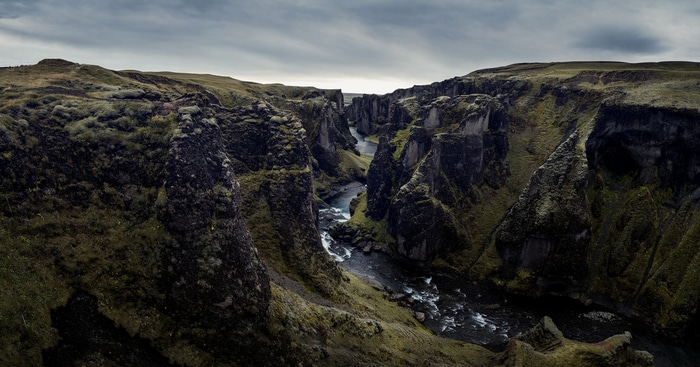 Fjaðrárgljúfur canyon in Iceland with a river flowing through