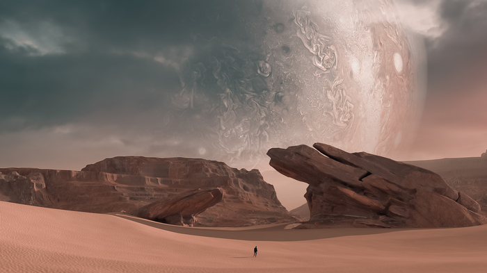 Person walking on sand dunes with Jupiter in the sky