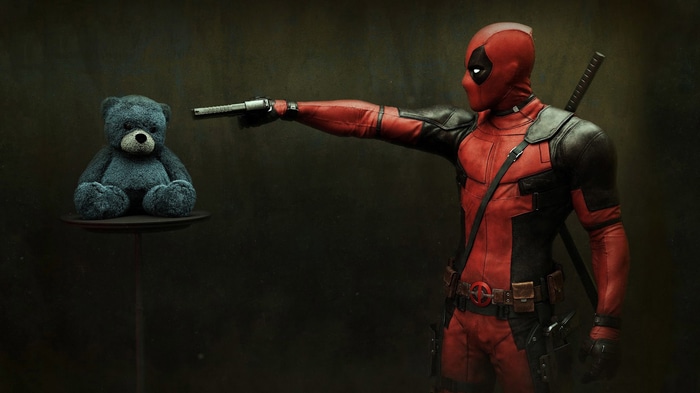 Deadpool pointing a gun at a teddy bear
