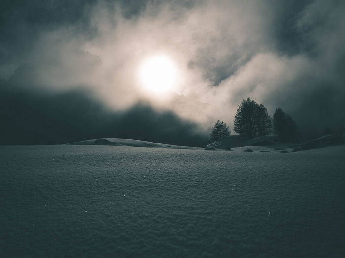 Snowy landscape with sun and clouds