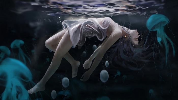Woman floating underwater with jellyfish