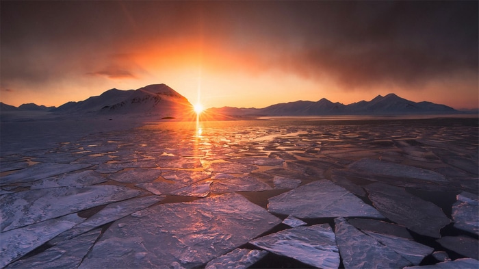 Sunset over icy landscape with mountains in Svalbard