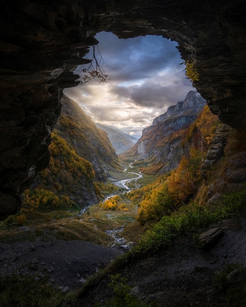 View of a valley with a river from a cave entrance