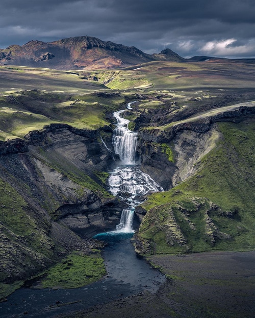 Waterfall in Iceland with mountains and river