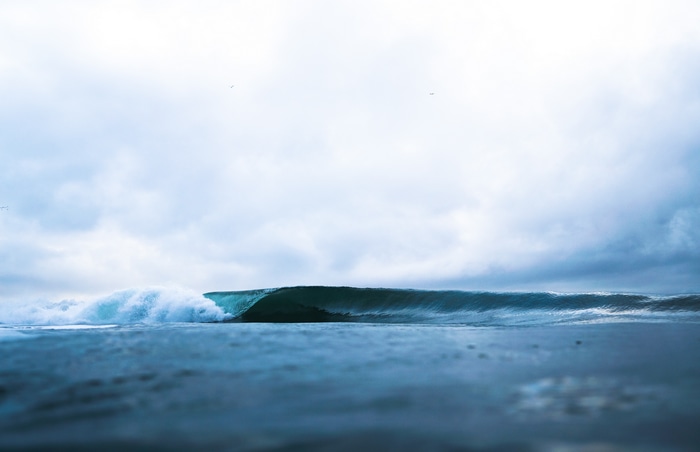 Ocean wave breaking under a cloudy sky