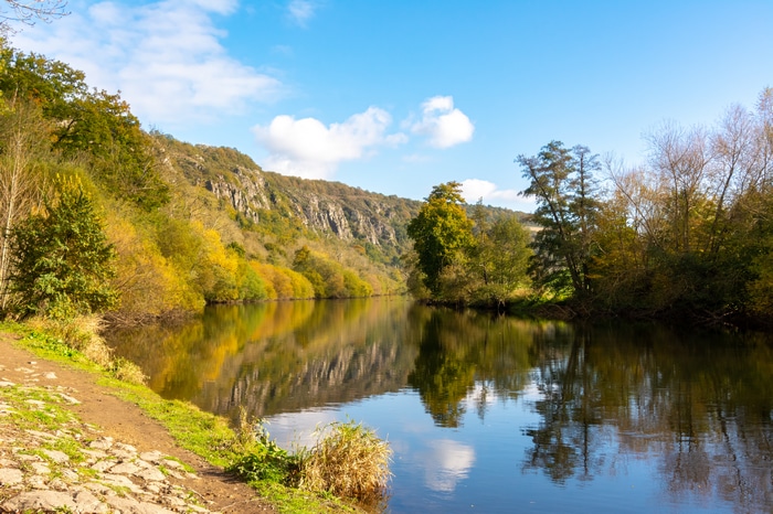 4K river reflection with trees and rocky hills