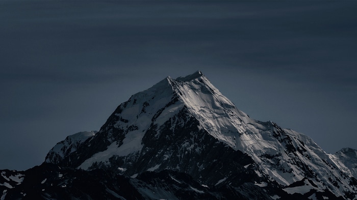 Snowy mountain peak under a dark sky