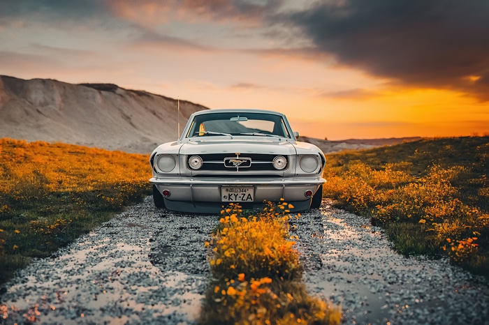 4K Silver Ford Mustang on a dirt road at sunset