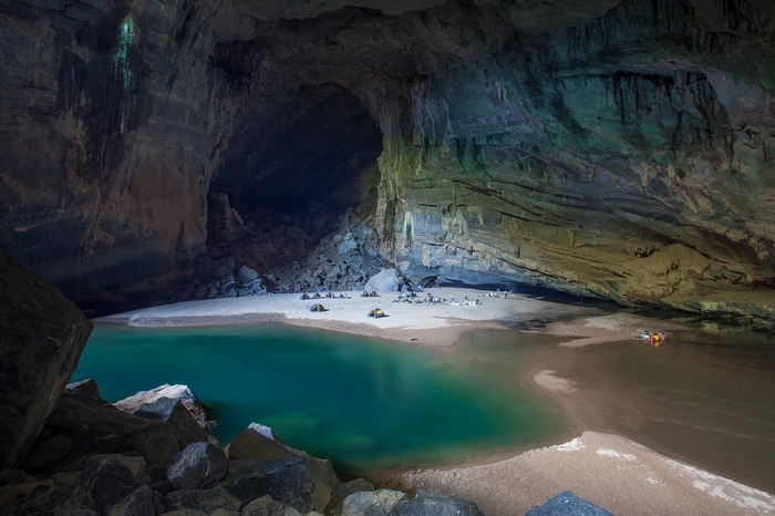 Hang Son Doong cave in Vietnam with tents and a turquoise pool