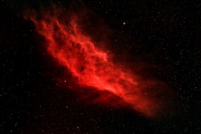 Red nebula in a star-filled galaxy