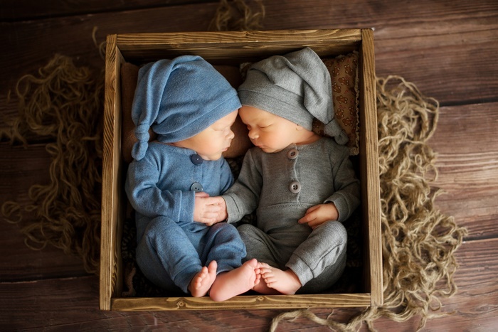 Two Newborn Twins Sleeping in a Wooden Box