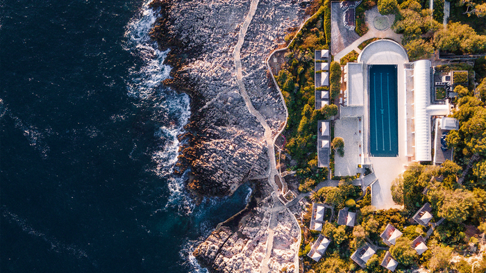 Aerial view of a coastal resort with a swimming pool