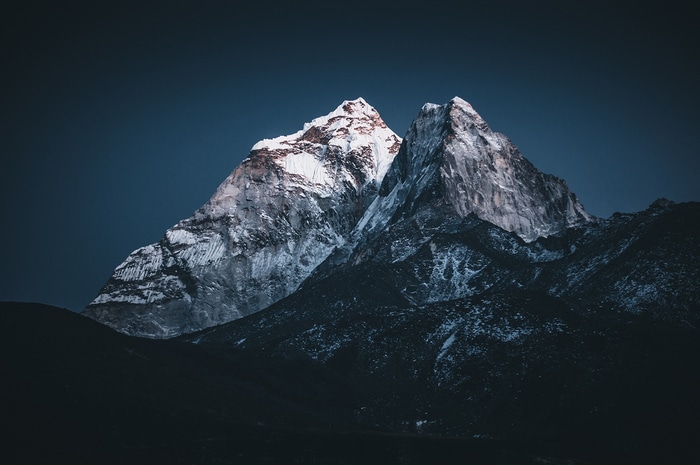 Snow-capped mountains under a dark blue sky