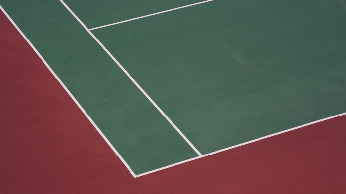 Tennis court with green and red surface and white lines