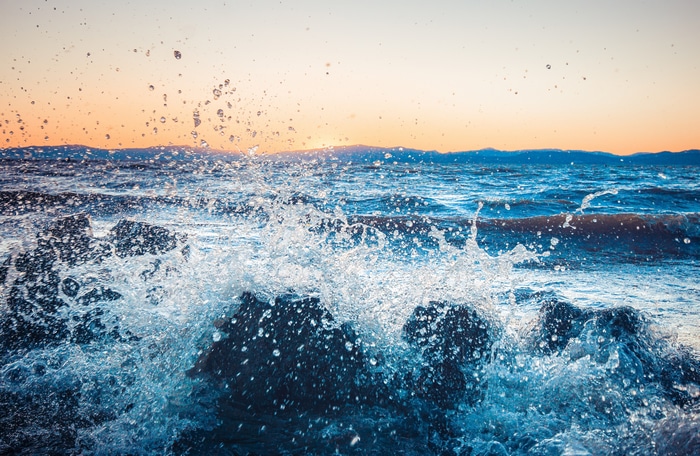 4K waves crashing on rocks at sunset