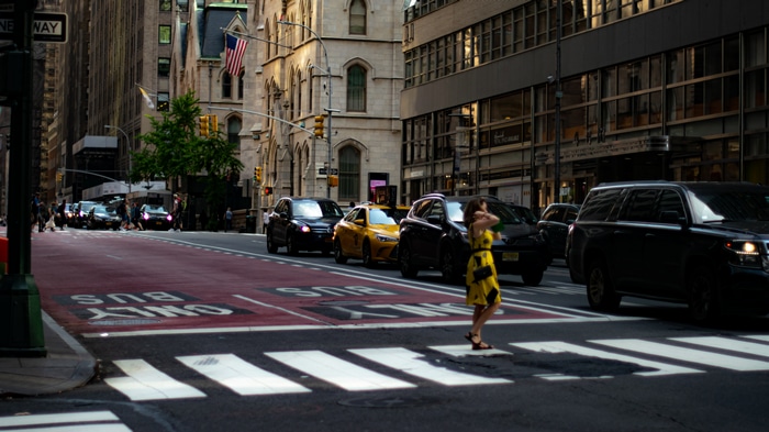 Woman in yellow dress crosses street in New York City