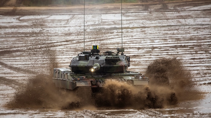 4K military tank driving through mud