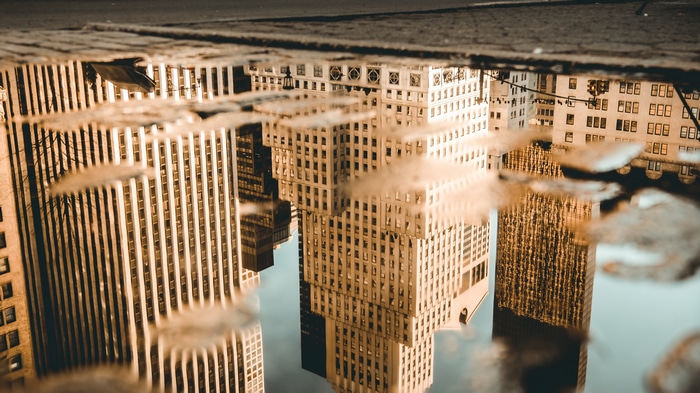 Skyscrapers reflected in a puddle