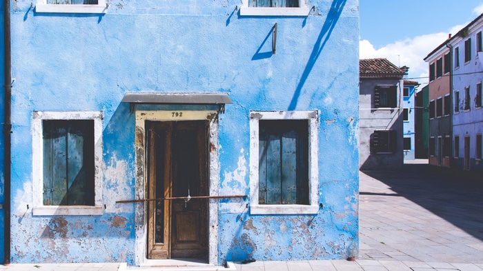 Blue house with peeling paint and wooden door