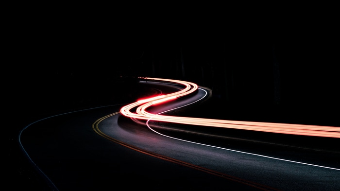 Long exposure of taillights on a winding road at night