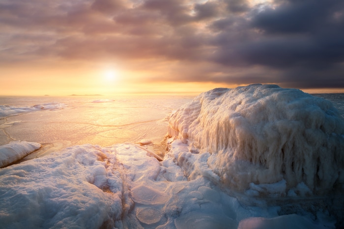 Frozen landscape at sunset with dramatic clouds