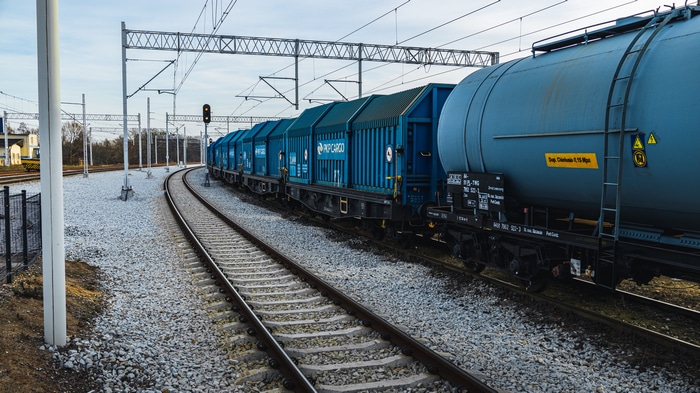 Blue cargo train on railway tracks