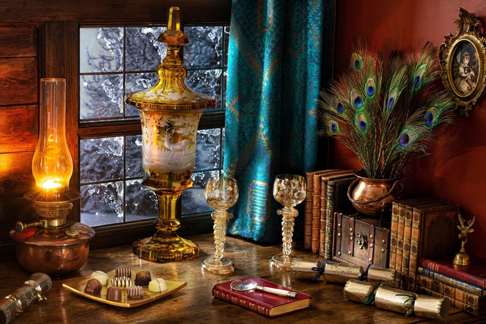 Still life with lamp, books, and peacock feathers