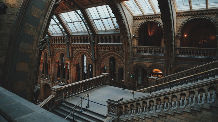 Interior of a grand stone building with arched windows and stairs