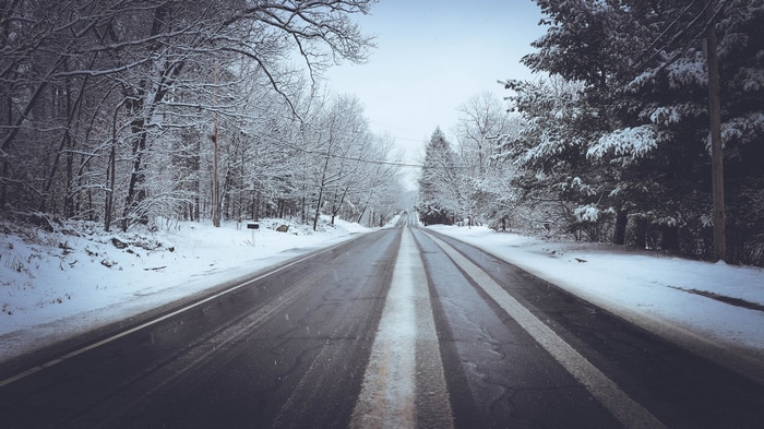 4K road through a snow-covered forest with power lines