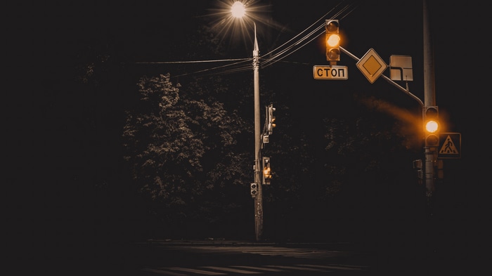 Nighttime intersection with traffic lights and street lamp