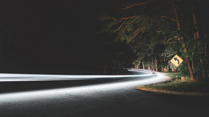 Long exposure of headlights on a winding road at night