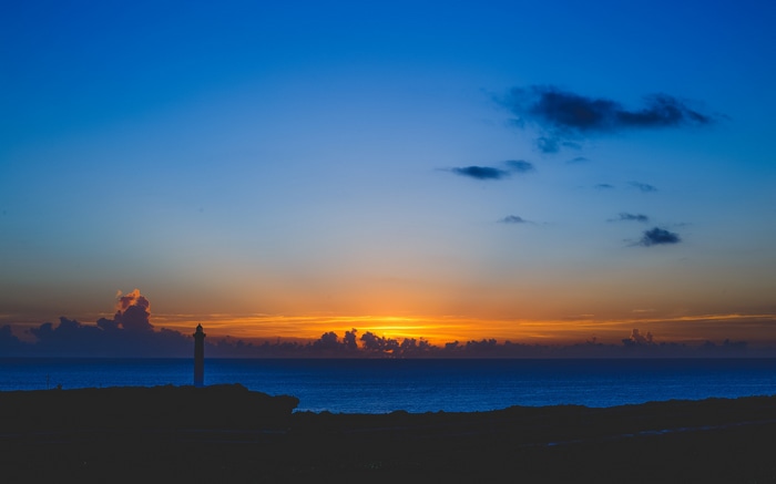 Lighthouse at sunset over the ocean