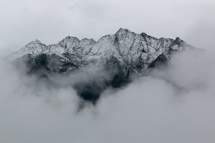 Snow-capped mountains shrouded in clouds
