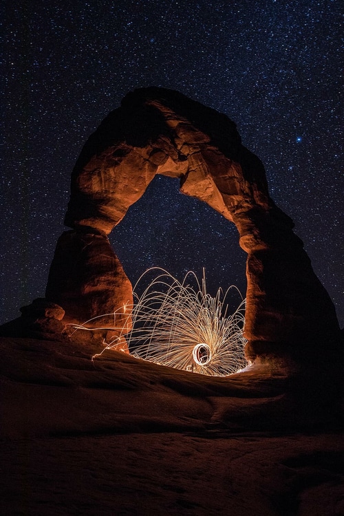 Steel Wool Sparks Under Delicate Arch at Night