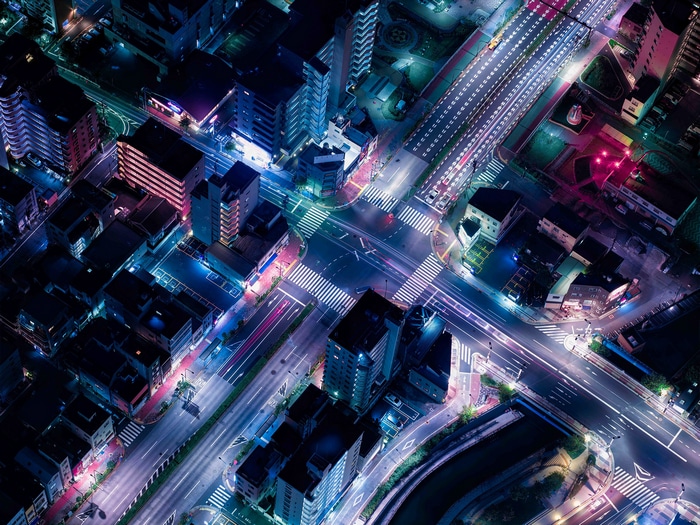 Aerial view of a city crossroads at night with light trails