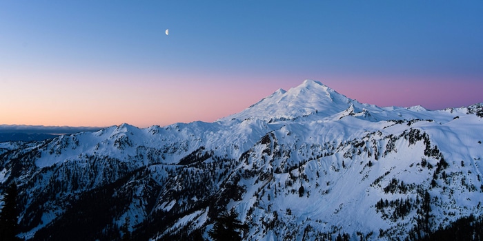 Moon over snow-covered mountains in Washington, USA