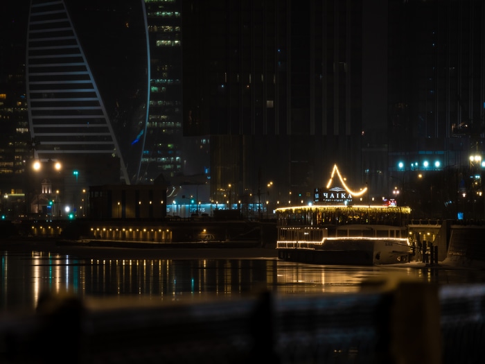 Moscow city at night with a boat on the river