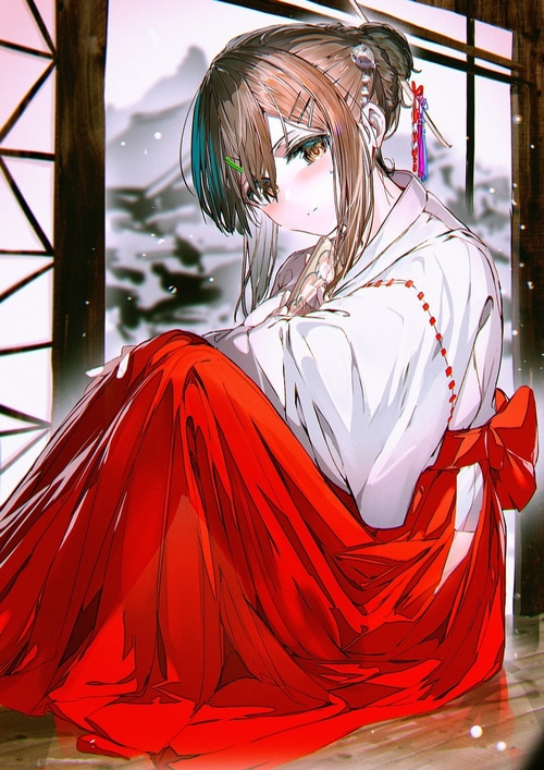 Miko in a red and white kimono with snow in the background