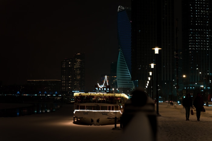 Night view of Moscow city with buildings and a boat