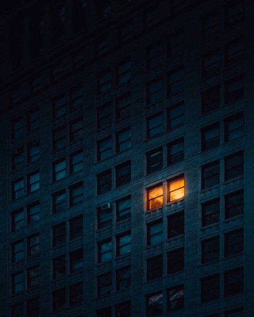 Building with one lit window at night