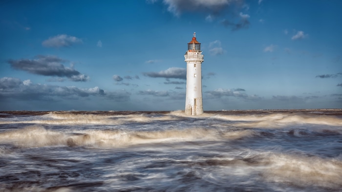 4K lighthouse in rough seas under a cloudy sky