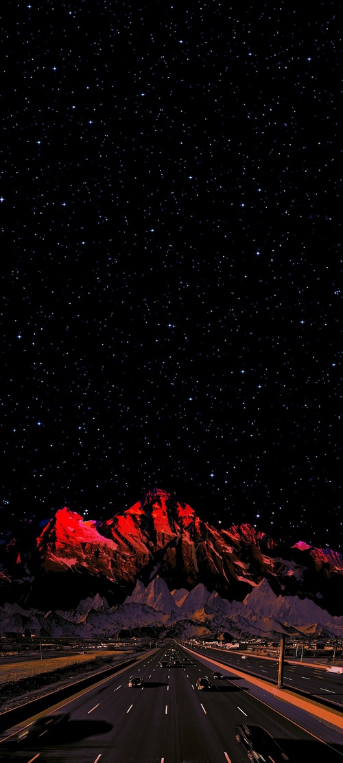 Night highway under starry sky with red mountains