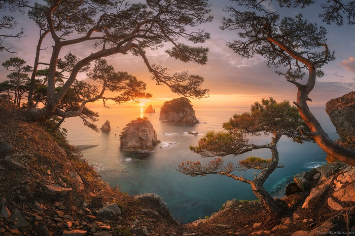 Daniel Kordan sunset over rocky islands and pine trees