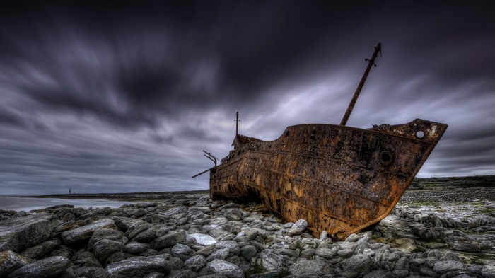 4K Rust Shipwreck on Rocky Shoreline