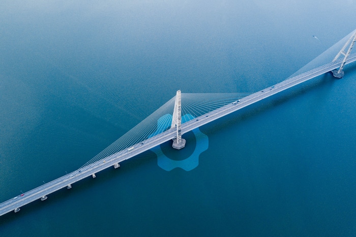 Cable-stayed bridge over blue water with logo